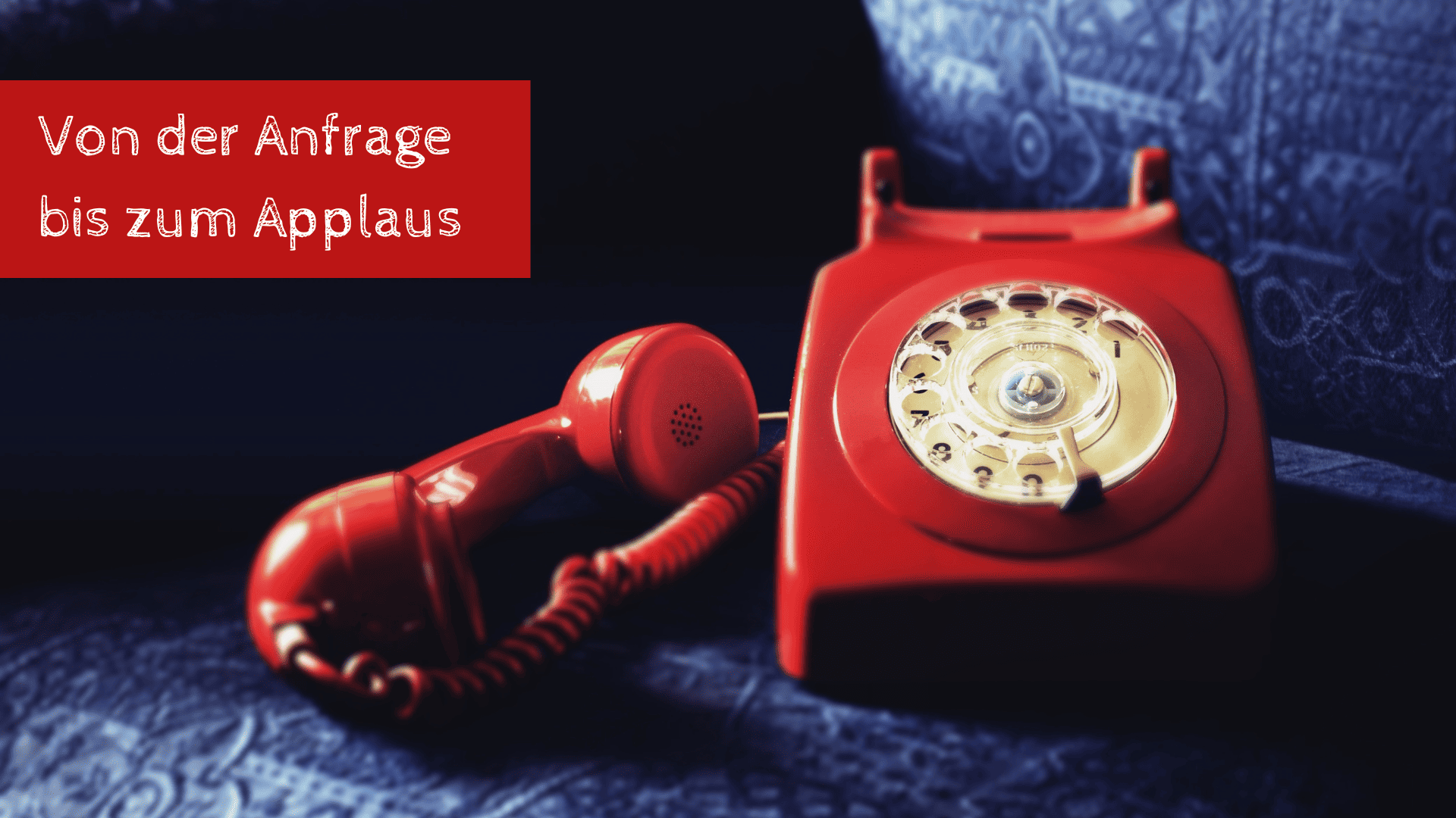 Blog_Anfrage_Buchung_Applaus Altes rotes Telefon mit Blogtitel "Von der Anfrage bis zum Applaus"